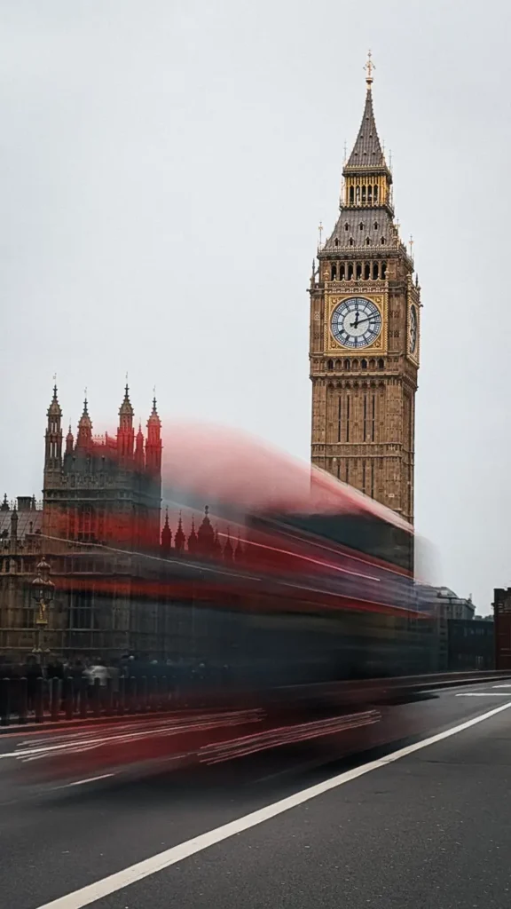 Foto met lange sluitertijd van een voorbijrijdende rode dubbeldekker met Big Ben op de achtergrond - getrokken vanaf westminster bridge