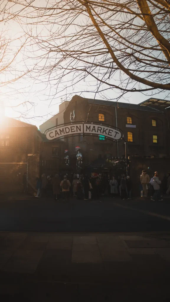 Ingang van Camden Market in Londen met mensen bij zonsondergang