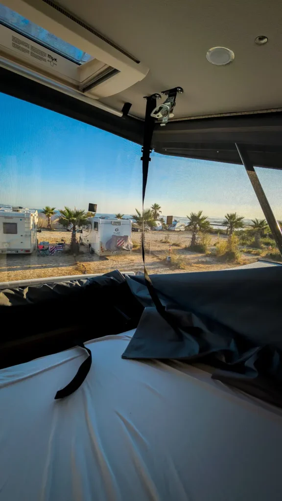 Uitzicht vanuit camperbed op camping in de Balkan
