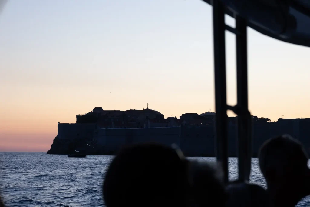 Silhouet van Dubrovnik gezien vanaf een boot tijdens zonsondergang