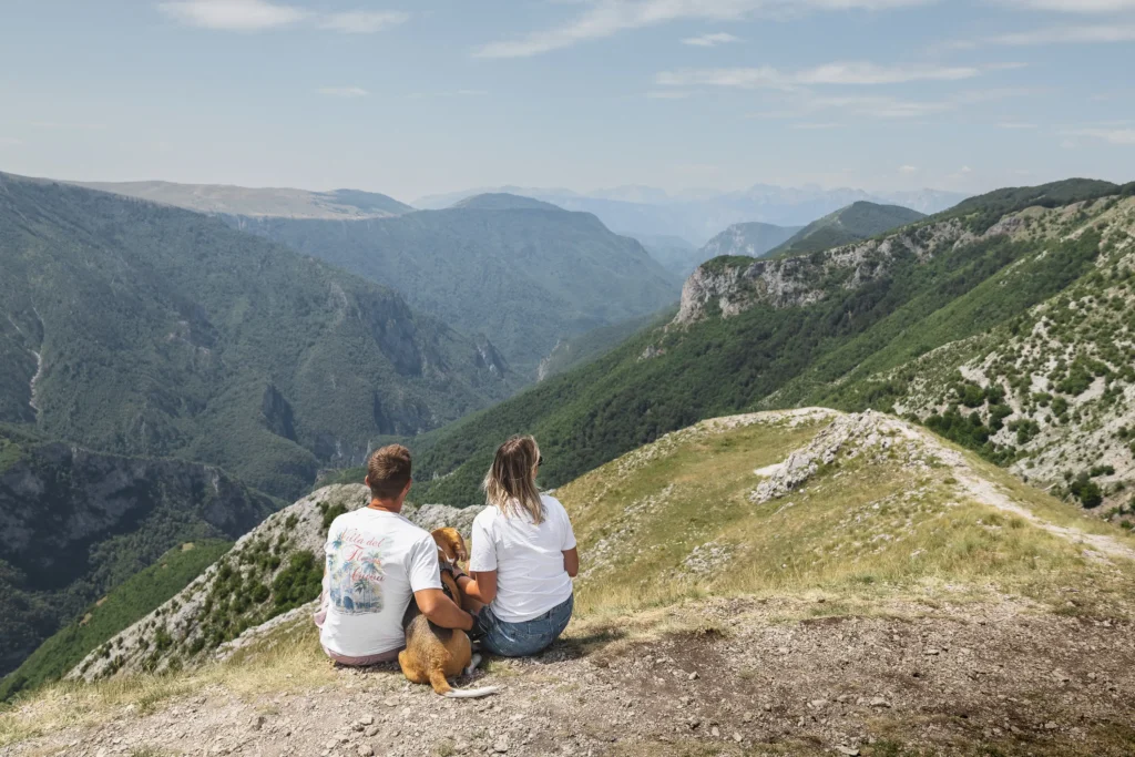 Koppel met hond in de bergen van lukomir op roadtrip met camper door de balkan