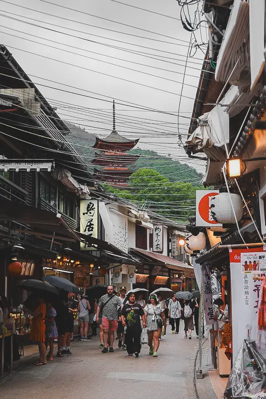 Drukke hoofdstraat van Miyajima met zicht op de vijf verdiepingen tellende pagode