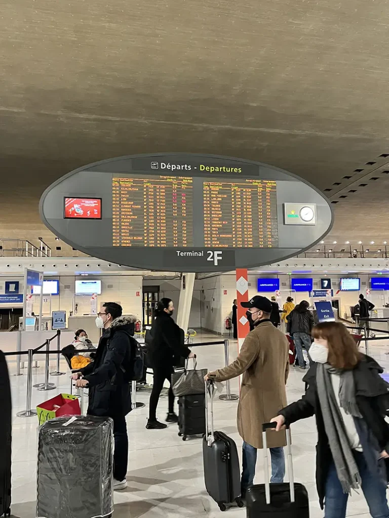 Drukke vertrekhal met reizigers en koffers bij check-in voor internationale vluchten