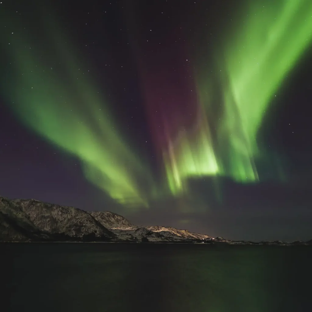 Noorderlicht fotograferen met camera instellingen voor bewegende aurora boven berglandschap