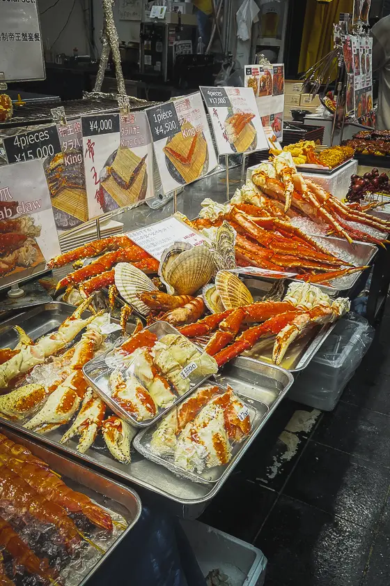 Verse king crab en schelpen op een seafoodkraam in Kuromon Market in Osaka.