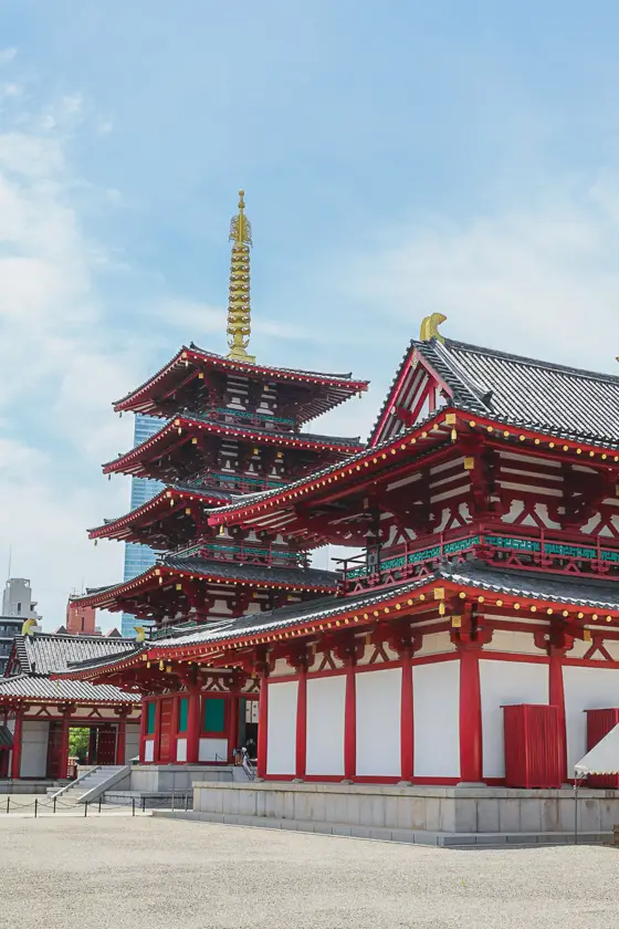 Rode en witte gebouwen van Shitennoji Tempel met pagode onder een heldere blauwe lucht in Osaka.