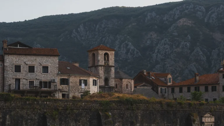 Historische gebouwen van Kotor met de indrukwekkende bergen van Montenegro op de achtergrond.