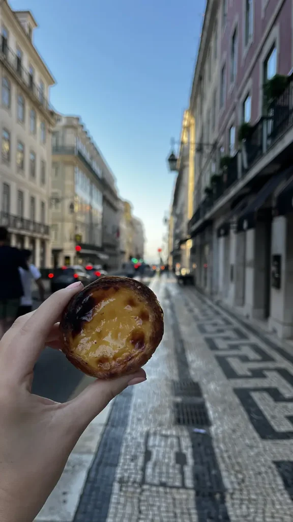 pasteis de nata met een leuke wijk in lissabon op de achtergrond