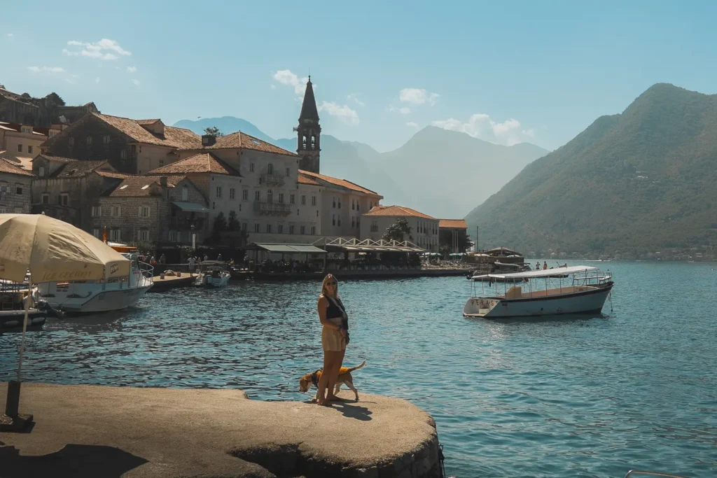 Persoon met hond aan water in Perast Montenegro