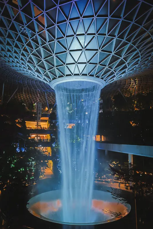 Rain Vortex waterval in Jewel Changi Airport bij nacht tijdens een Singapore layover.