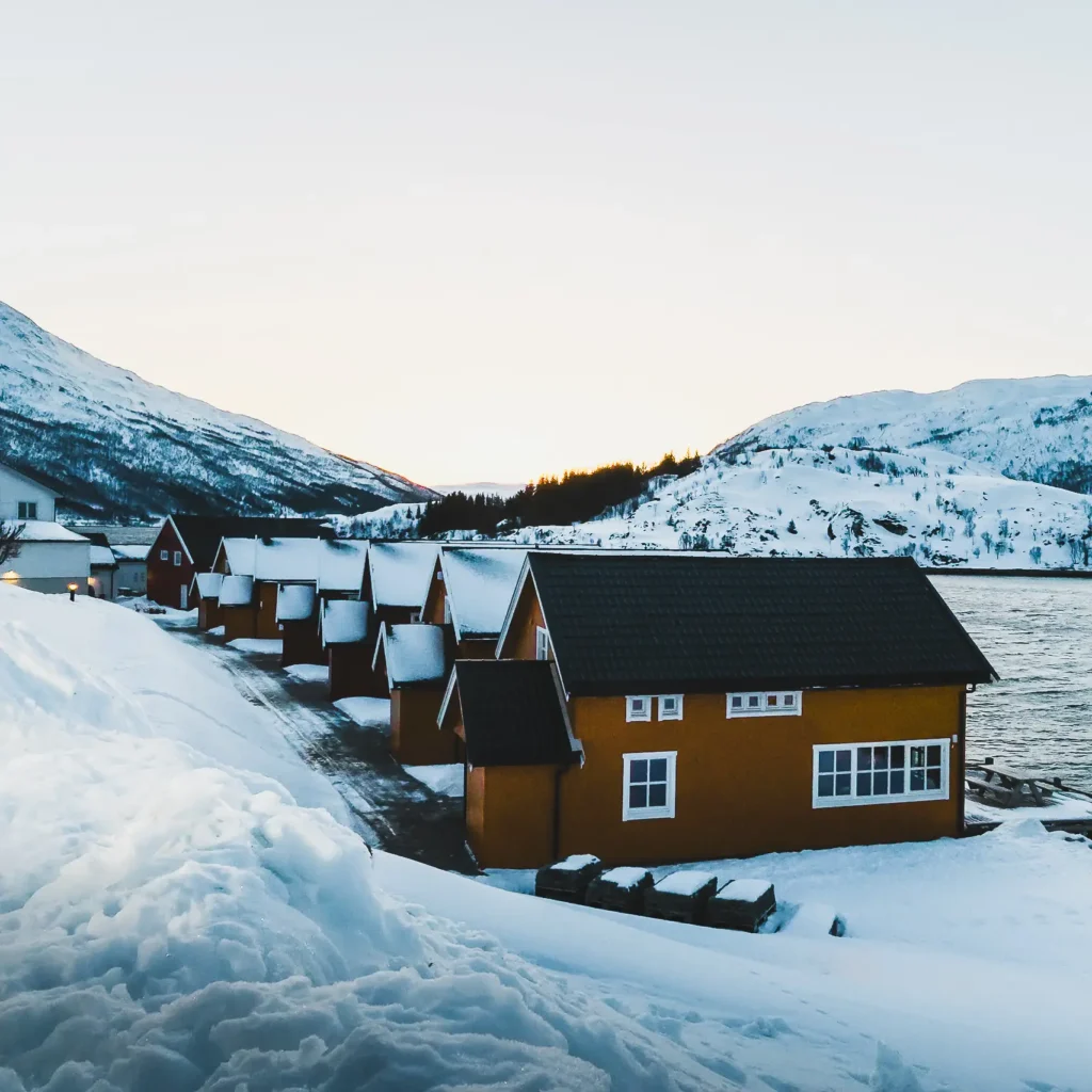 Houten cabins van Lauklines in sneeuwlandschap bij Tromsø