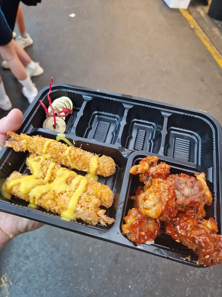 Lunchtray bij Tongin Market in Seoul met traditionele muntjes en verschillende Koreaanse streetfoodgerechtjes