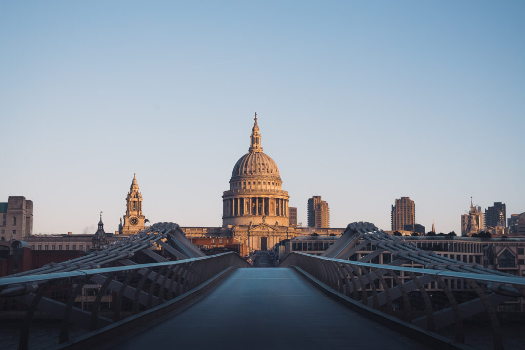 Foto van st paul's cathedral getrokken vanaf millenium bridge in de ochtend met zon op de koepel