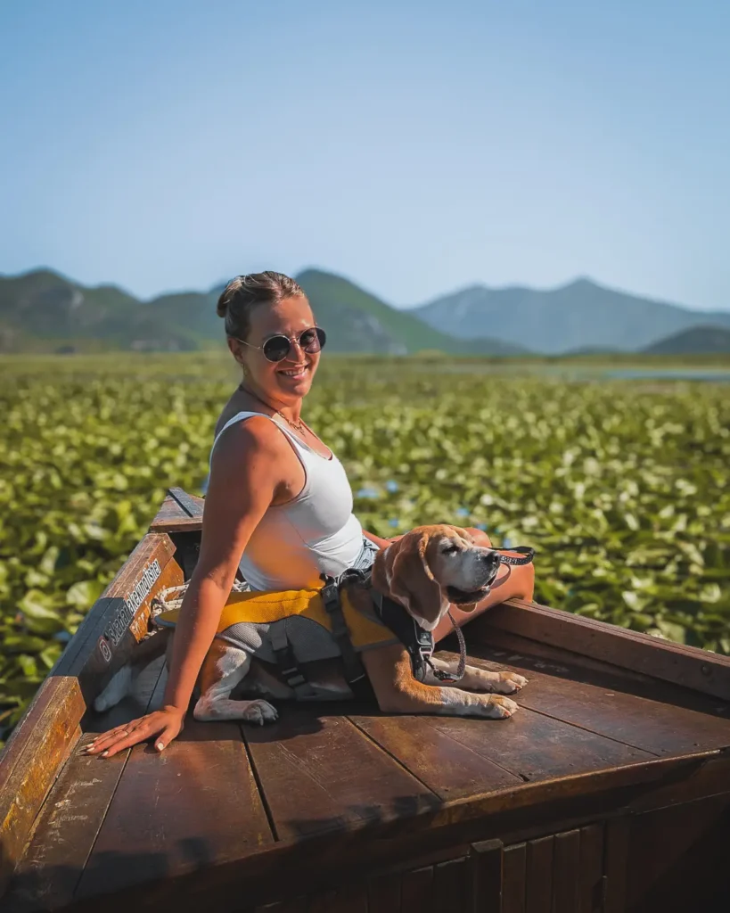 Vrouw met hond op traditionele boot tijdens Balkan roadtrip