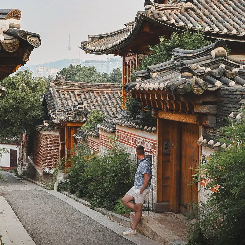 Reiziger die uitkijkt over traditionele hanokhuizen in Bukchon Hanok Village in Seoul