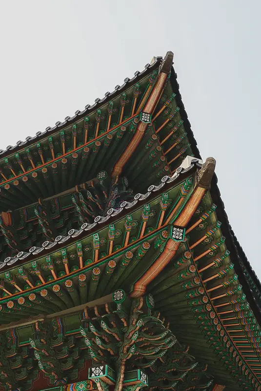 Detail van de kleurrijke dakdecoratie en houten balkstructuur van Changdeokgung Palace in Seoul