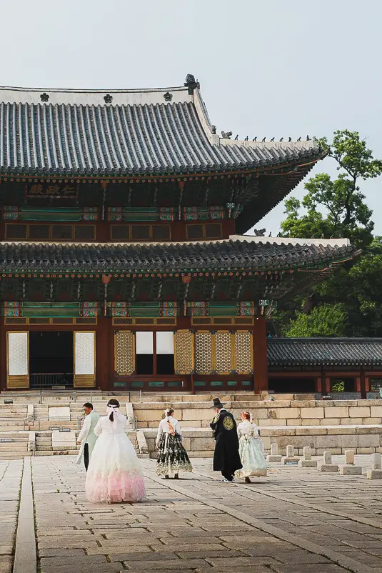 Bezoekers in traditionele hanbok voor een paleisgebouw in Changdeokgung Palace in Seoul