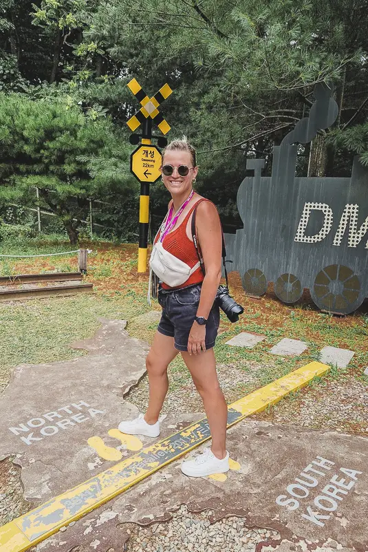 Reiziger staat op de symbolische grenslijn tussen North Korea en South Korea in Imjingak Park tijdens de DMZ-tour
