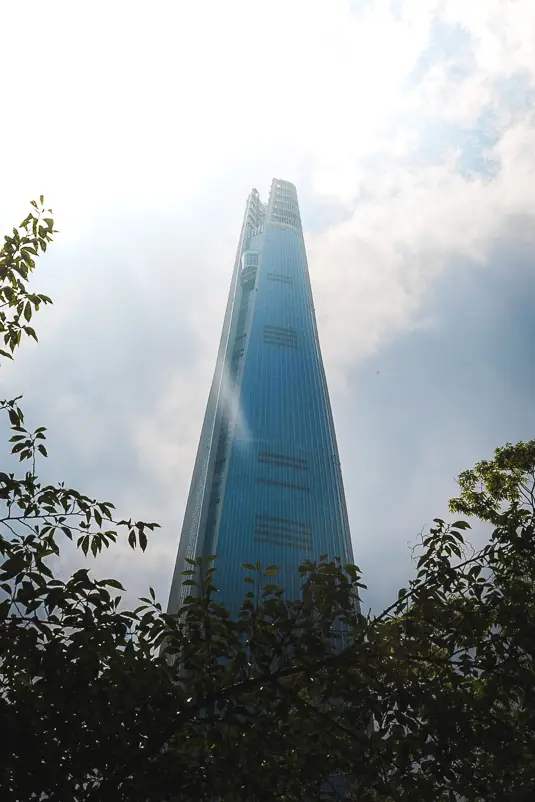 Close-up van de Lotte World Tower in Seoul gefotografeerd van onderaf tussen bomen