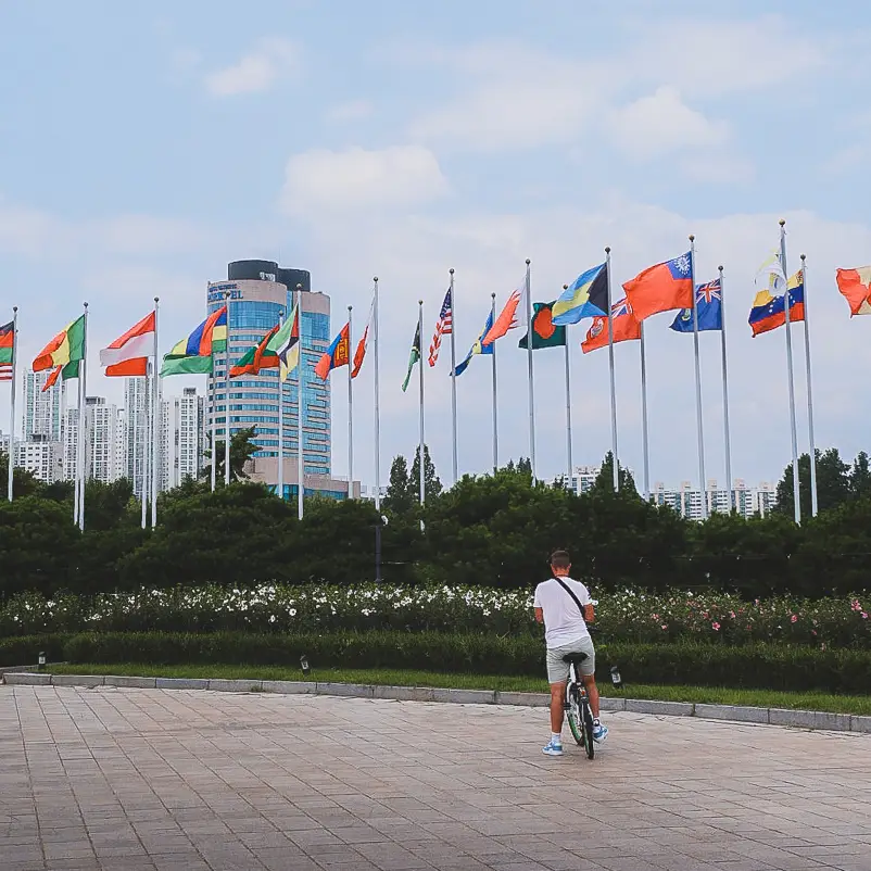 Reiziger fietst langs de Olympische vlaggen in het Olympisch Park in Seoul
