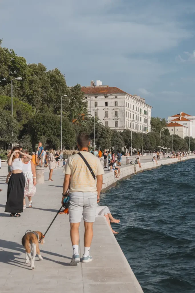 Bezoekers wandelen langs de waterkant van Zadar bij de Riva